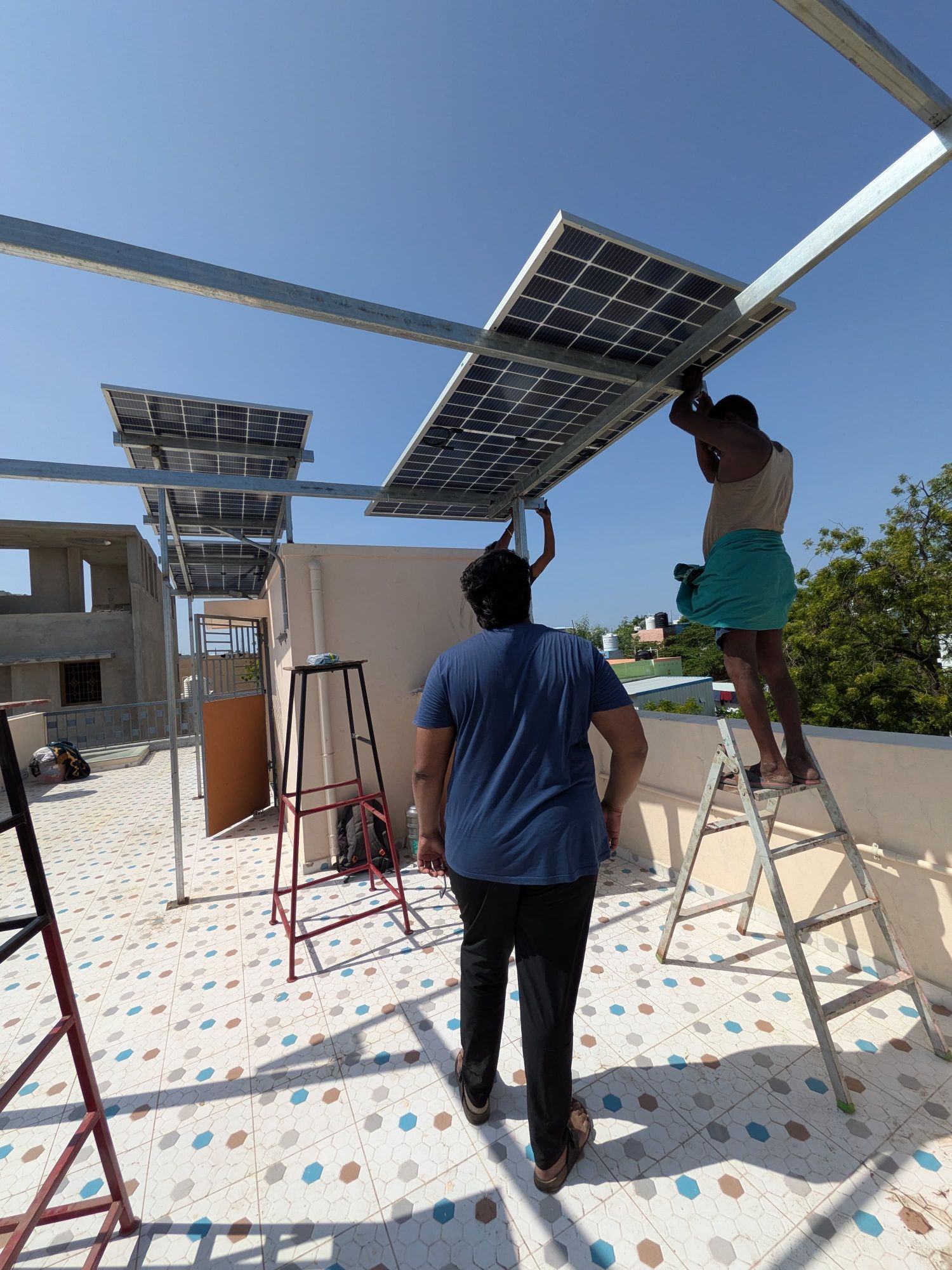 Quadbiz team fitting panels on a rooftop in Madurai